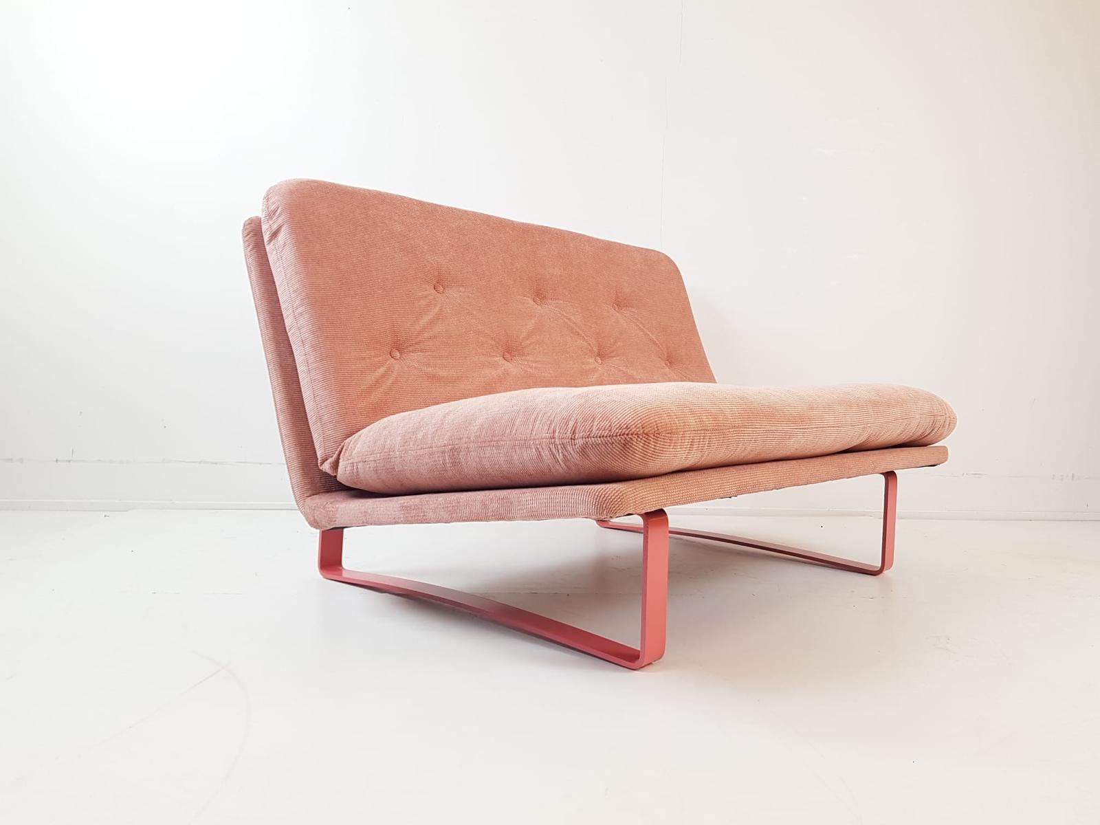 Vintage loungestoel in zalmroze stof met slanke metalen poten